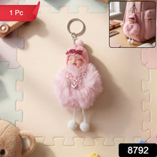 Close-up view of plush doll and fluffy fur ball keychain showing soft texture
