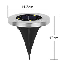 Single solar LED garden light glowing brightly at night in outdoor garden setting