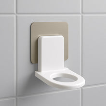 Close-up of a white wall-mounted shampoo holder with a bottle.