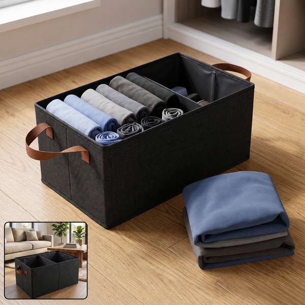 A black foldable fabric storage basket with two compartments filled with rolled clothes, on a wooden floor.
