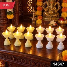 Twelve LED diya candles, six yellow and six white, illuminate a wooden altar with a golden Ganesha statue and marigold