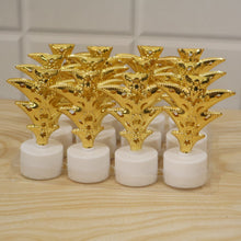 A set of twelve golden Christmas tree LED tealight candles are packaged in clear plastic on a wooden surface.