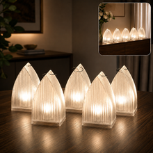 Five clear plastic ribbed lanterns with warm LED lights on a wooden table, with an inset showing them on a dark cabinet.