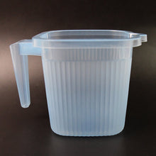 Close-up of the Transparent Bath Mug's sturdy handle and square shape.