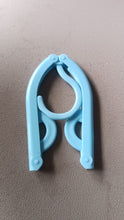 Single travel hanger shown in its fully compact, folded position for easy portability.