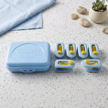 A light blue plastic storage case and six blue and yellow plastic clips are arranged on a speckled white countertop next to