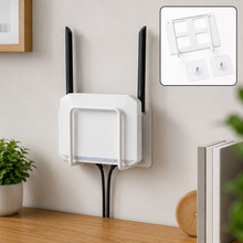 A white WiFi router is mounted to a wall using a white metal bracket, with two adhesive hooks shown in the corner.