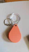 Magnifying glass keychain hanging from bag as portable magnifier