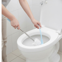 The toilet brush with holder in a clean, minimalist bathroom setting.