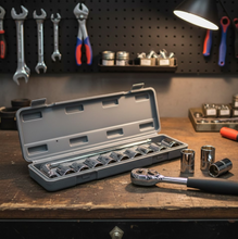 An open grey socket wrench set case sits on a wooden workbench with a ratchet and sockets scattered.
