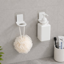 Product box for wall-mounted dispenser holders, alongside two white plastic holders and their clear adhesive pads on a