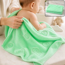 A baby is being dried with a light green microfiber towel featuring embossed heart and flower patterns.
