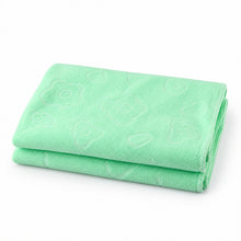 A light green microfiber towel with subtle embossed patterns, folded neatly on a white background.
