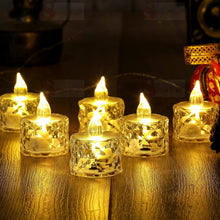 Six clear acrylic flameless LED tealight candles with warm yellow light on a reflective wooden surface.