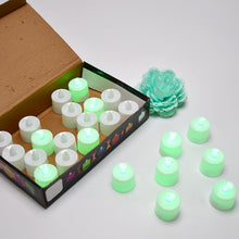 An open brown box contains twenty-four white flameless LED tealights, with several more glowing tealights on the white table.
