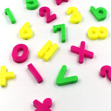 Assorted magnetic number and symbol pieces arranged for engaging preschool learning.