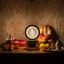 A Ganpati 3D crystal light on an altar with a Ganesha idol, incense, a diya, and marigold flowers.