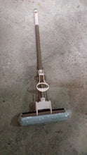 The sponge mop effectively cleaning a tiled floor, demonstrating its dirt removal capabilities.
