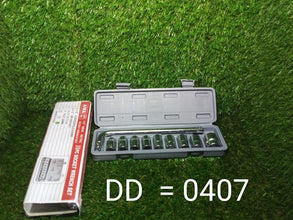 An open grey socket wrench set case and a white product box are on a green textured surface.