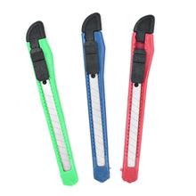 Three utility knives, one green, one blue, and one red, arranged diagonally on a white background.