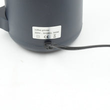 All components of the electric grinder: transparent lid, grinding chamber, and sturdy base.