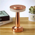 Modern LED desk lamp with touch control and warm light on a wooden surface.