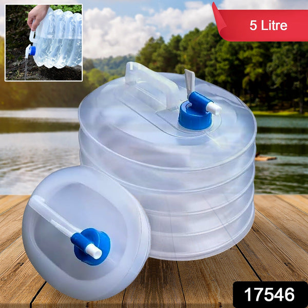 A translucent collapsible water container with a blue spigot sits next to its collapsed form on a wooden surface by a lake.