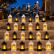 Twenty-four small black and white lanterns with glowing LED candles arranged on outdoor steps at dusk.