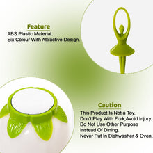 A close-up of a green dancing doll fruit fork and the base of the white flower-shaped stand with green accents.