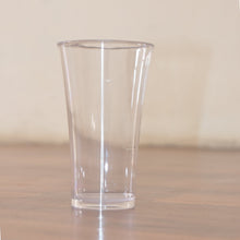 Stack of transparent plastic water glasses for compact storage.