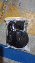 The black magnetic wireless car charger, air vent mount, and USB-C cable sealed in clear plastic packaging on a concrete