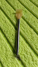 The compact back scratcher displayed neatly in its product packaging.