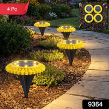 Four yellow and black solar ground lights illuminate a garden path at dusk, with a red 