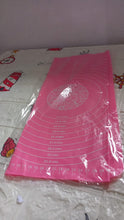 Hands rolling dough on the silicone baking mat, utilizing its non-stick property and guides.