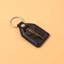 Close-up of decorative vintage style aircraft emblem on leather finish keychain