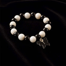 Close-up of black and white beads and cross pendant on bracelet