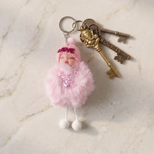 Close-up of plush doll's sleeping face and attached soft fur ball on keychain