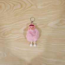 Plush doll keychain hanging on bag strap showing soft fur ball charm