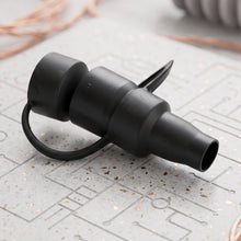 The black electric air pump, its detachable nozzle, and its product box are arranged on a wooden table.