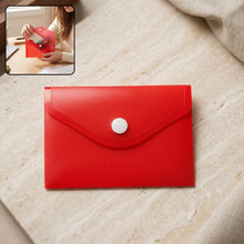 A red plastic document folder envelope with a white button closure lies on a light marble surface, with an inset showing a