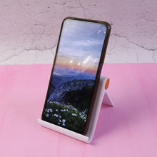 Slim white foldable plastic desktop mobile stand holding smartphone