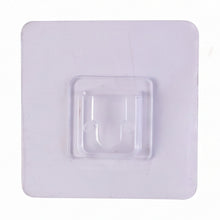 Transparent wall hook attached to a smooth surface for organization.