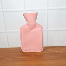 Small hot water bag in use for warm compress and pain comfort