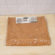 A rectangular brown bobble mat is sealed in clear plastic packaging with a white and black label on top.