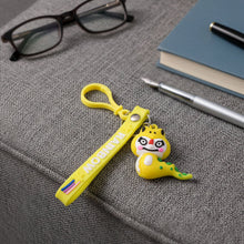 Dinosaur cartoon keychain attached via metal clip to bag zipper