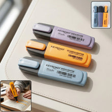 Three Keyroad Metallic highlighters in light blue, orange, and purple, with a person highlighting text in the bottom