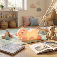Child's hand gently squeezing the soft silicone bear night light.