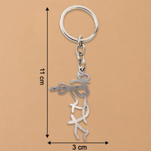 Polished stainless steel Krishna flute keychain on table