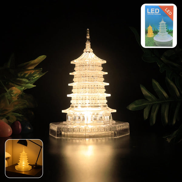 A clear, illuminated LED crystal pagoda light on a dark surface with green foliage and two small inset images.