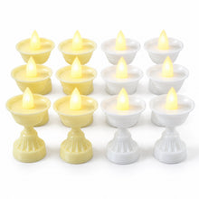 Twelve LED diya candles, six yellow and six white, are neatly arranged in rows on a plain white background.